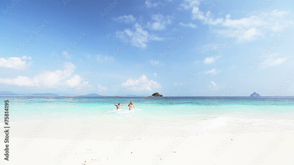 Young couple running into tropical sea Young couple running into tropical sea