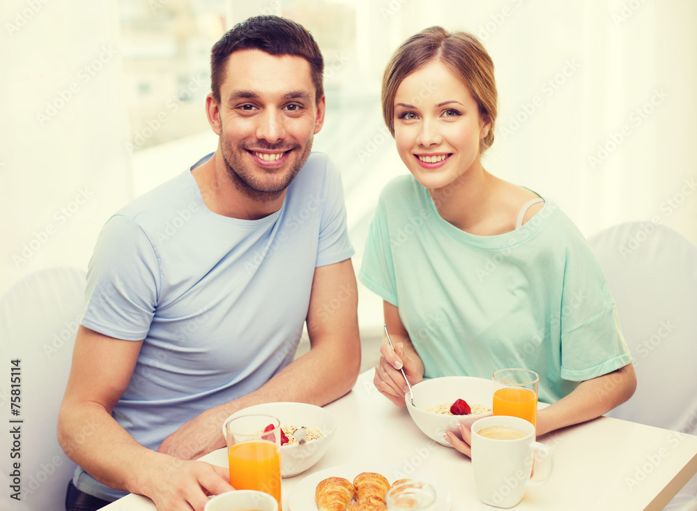 smiling couple having breakfast at home