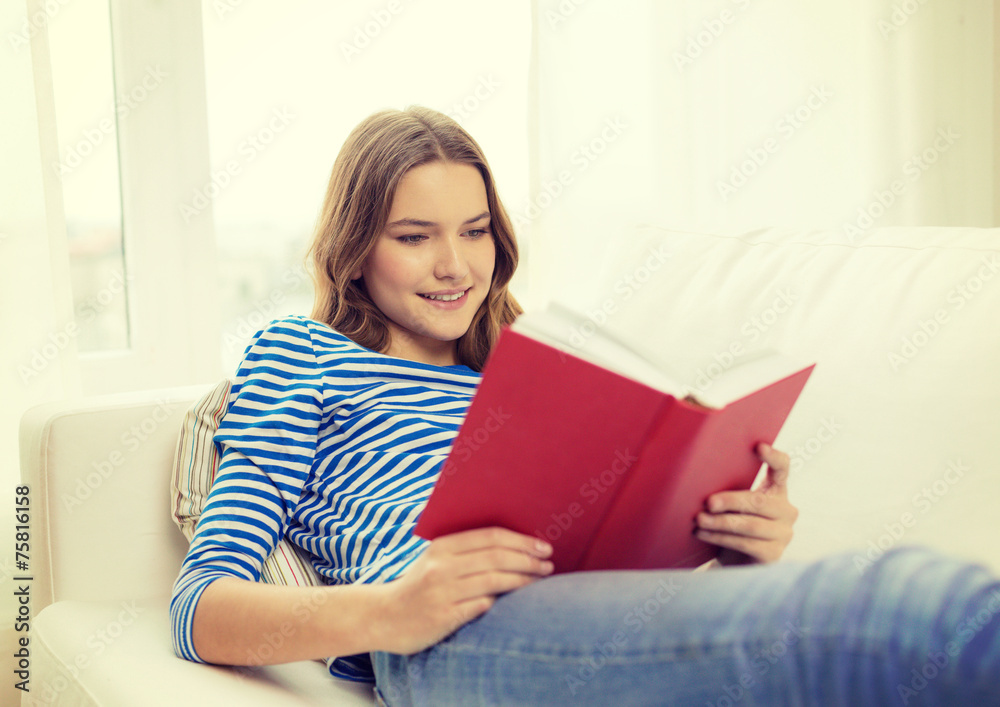 smiling teenage girl reading book on couch smiling teenage girl reading book on couch