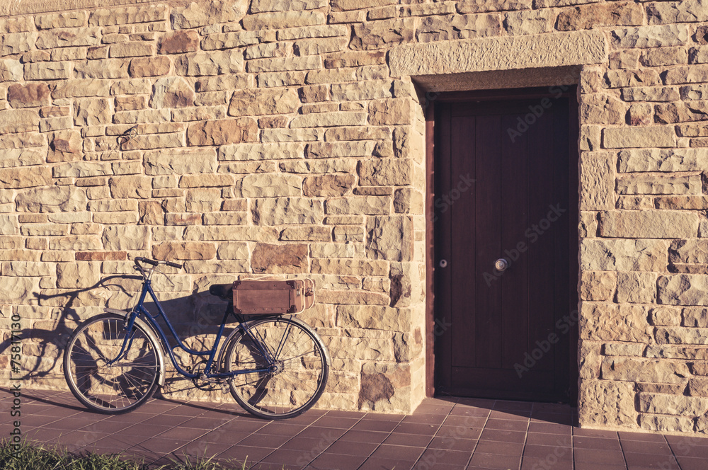 Vintage bicycle and old suitcase in a stone wall