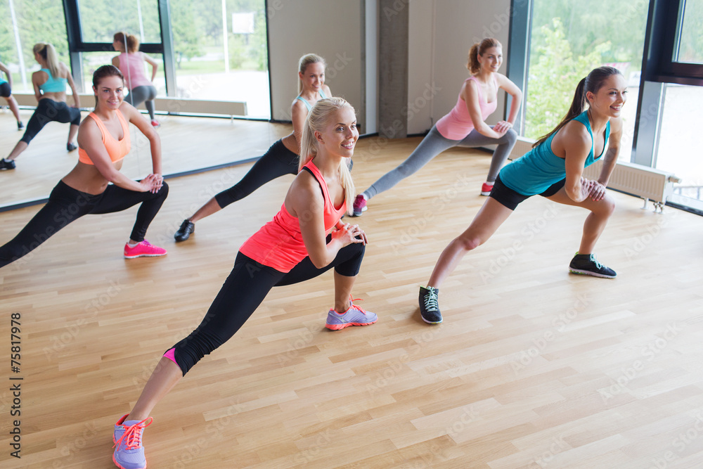 group of women making lunge exercise in gym