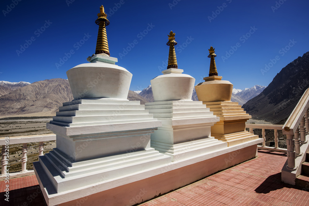 Three stupa and blue sky at Diskit monastery, Ladakh, India Three stupa and blue sky at Diskit monastery, Ladakh, India