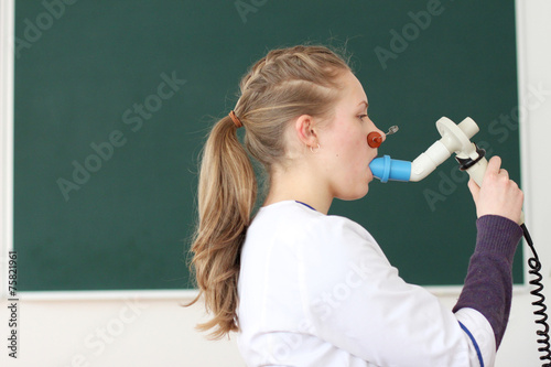 Profile of medical student doing spirometry test; photo