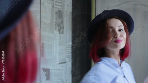 Woman applying makeup lipstick in front of the mirror