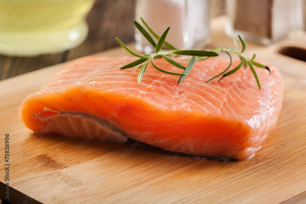 Raw salmon filet on wooden cutting board Raw salmon filet on wooden cutting board
