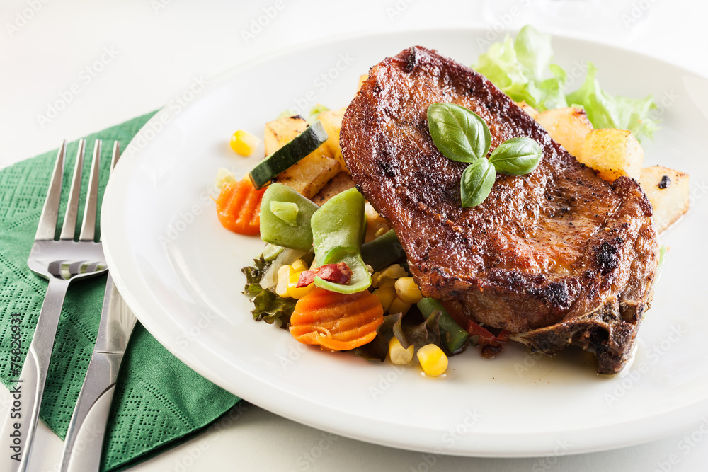 Fried pork with potatoes and vegetables salad