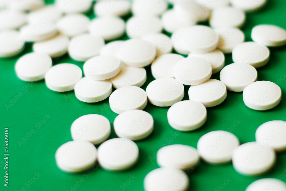 White pills on green background, differential focus White pills on green background, differential focus