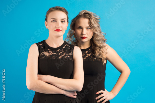 Two women in identical  dresses are angry at each other