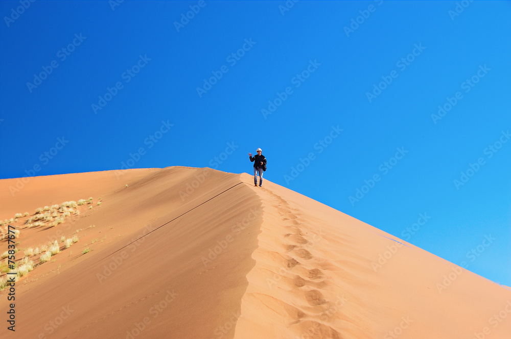 Man on dunes of Namib desert, Namibia, South Africa
