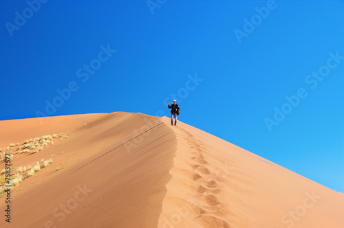Man on dunes of Namib desert  Namibia  South Africa
