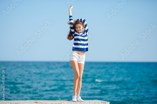 Young attractive woman near the ocean on a summer day