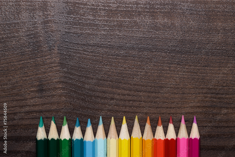 multicolored pencils over brown wooden table multicolored pencils over brown wooden table