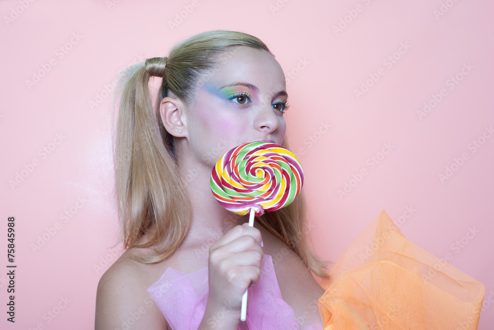 Girl holding a lolly pop, in pink background