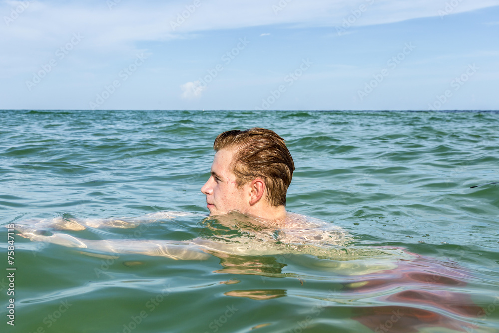 teenage boy enjoys swimming in the ocean
