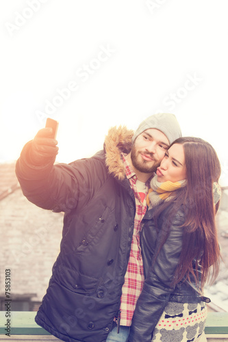 Attractive couple doing selfie outdoors.