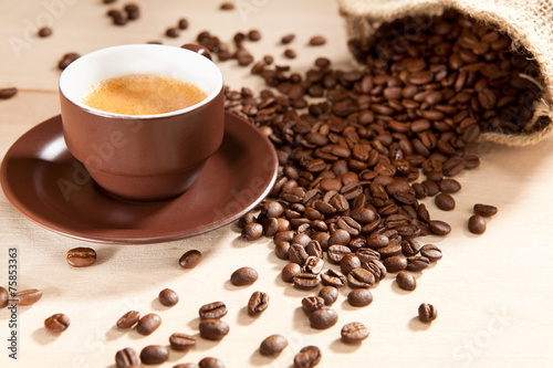 Eine Tasse Kaffee und Bohnen aus dem Jutesack