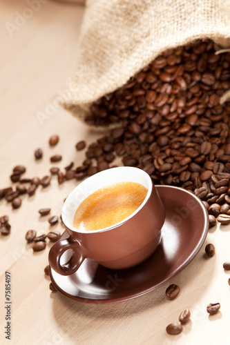 Eine Tasse Kaffee und geröstete Kaffeebohnen