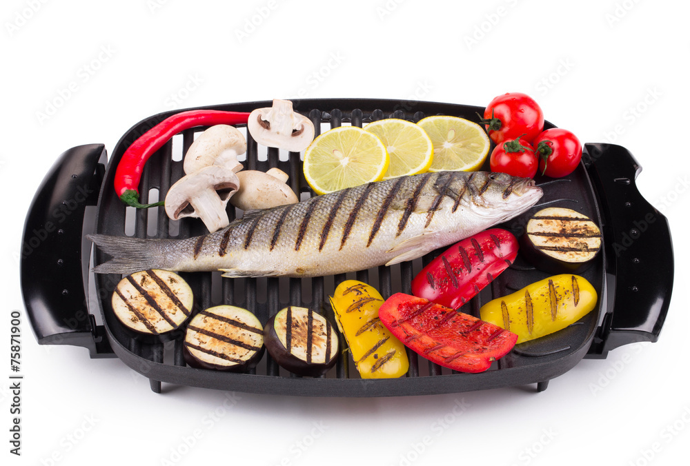 Grilled seabass on grill with vegetables.