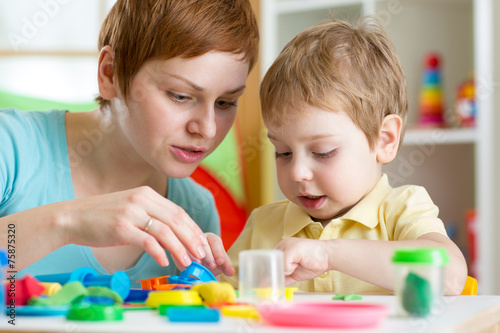 child boy and mother playing colorful clay toy