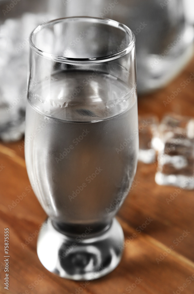 Glass of water with ice on wooden table background Glass of water with ice on wooden table background