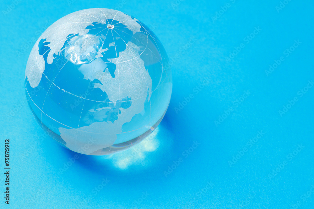 A glass globe, isolated on blue background A glass globe, isolated on blue background