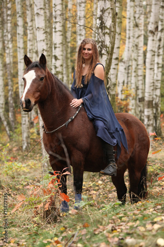 Amazing girl riding a horse without any equipment in autumn fore