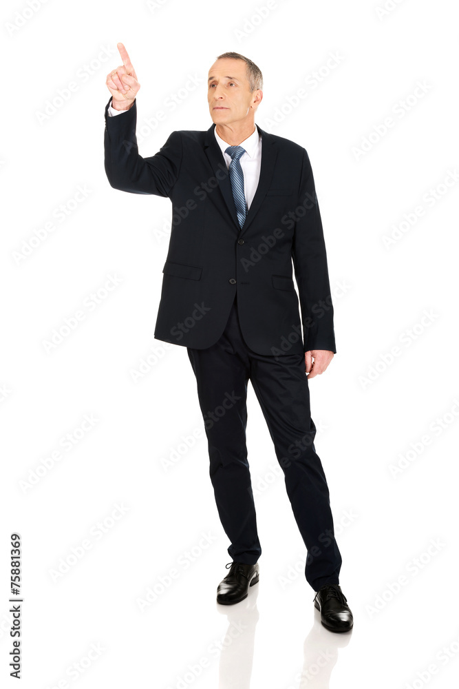 Full length businessman pressing abstract button Full length businessman pressing abstract button