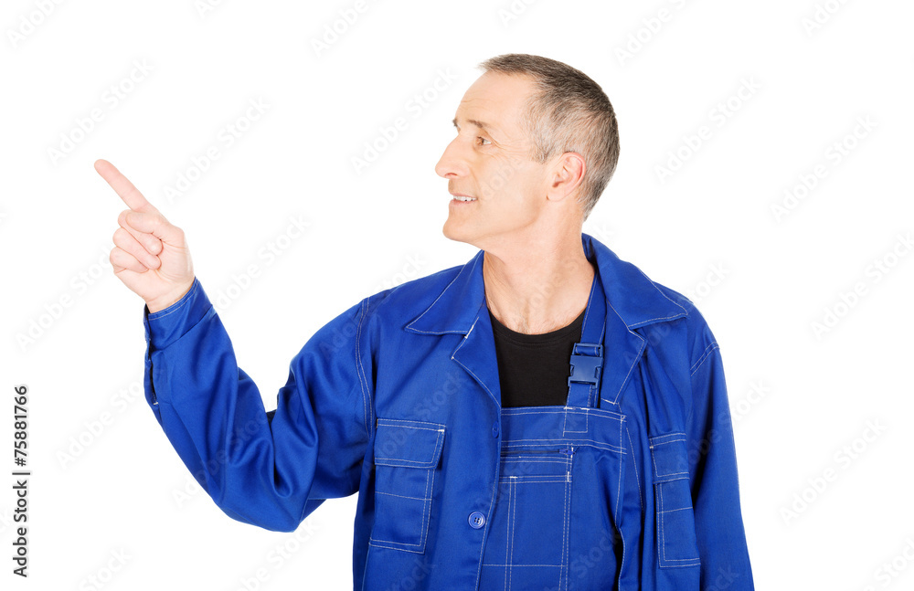 Portrait of smiling mature repairman pointing up Portrait of smiling mature repairman pointing up