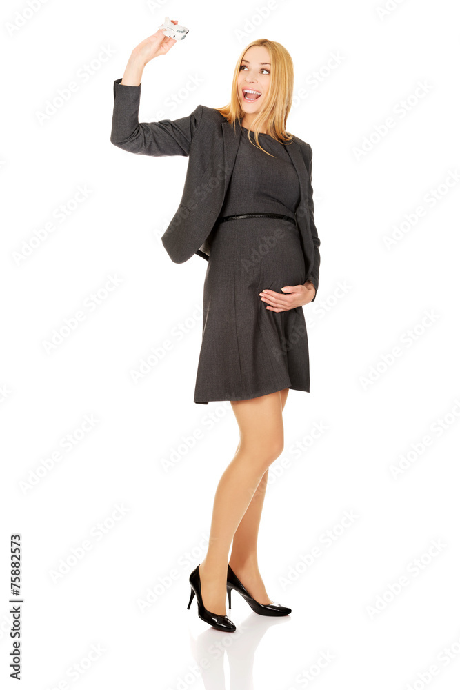 Pregnant businesswoman holding plane model Pregnant businesswoman holding plane model