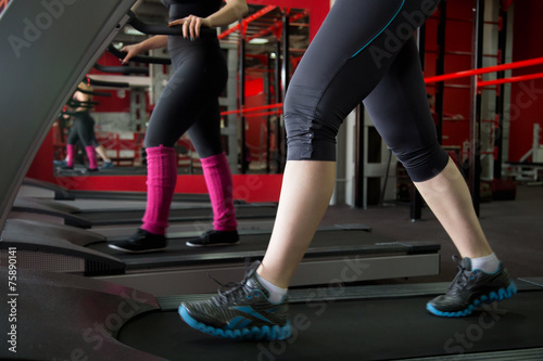 Women legs in sneakers on treadmill