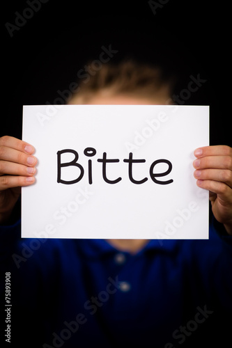 Child holding sign with German word Bitte - Please