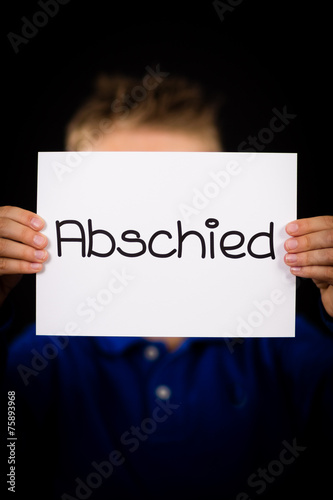Child holding sign with German word Abschied - Goodbye