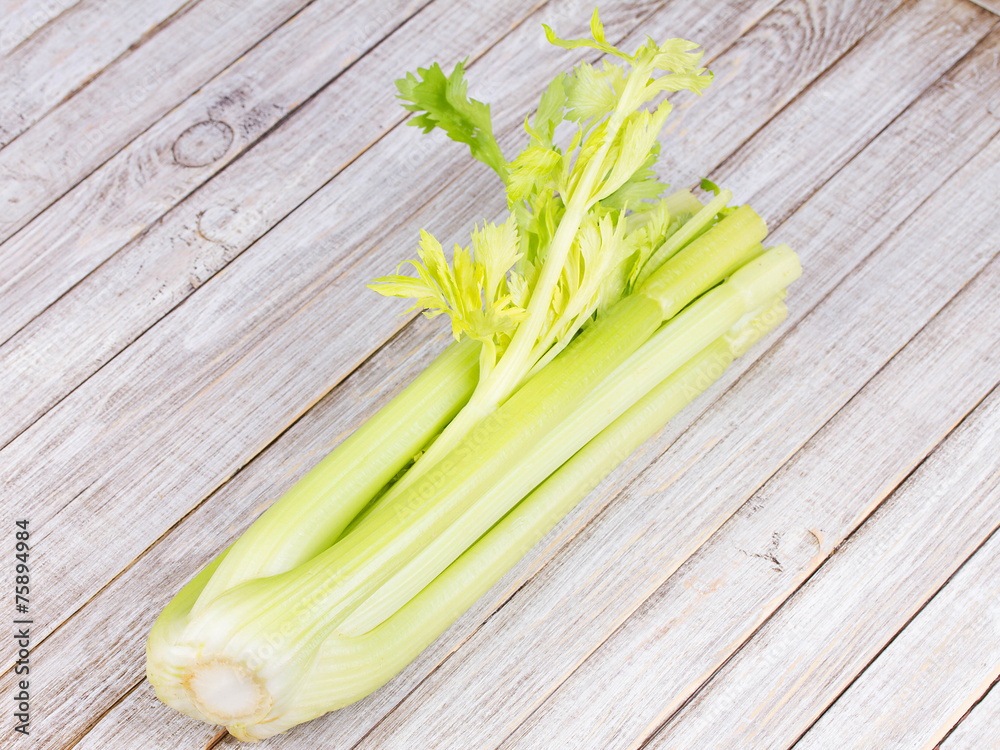 Organic vegetables - celery with leaves on wooden background Organic vegetables - celery with leaves on wooden background