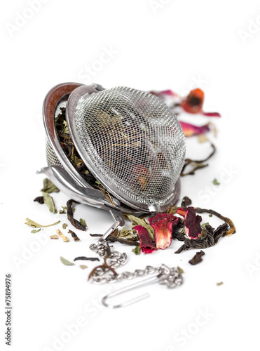 Canvas Print Green herbal tea with dried flowers in tea strainer