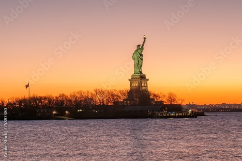 The silhouette of Statue of Liberty in New York City at sunrise