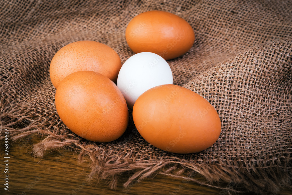 Brown and white eggs on burlap and wooden rustic table. Brown and white eggs on burlap and wooden rustic table.