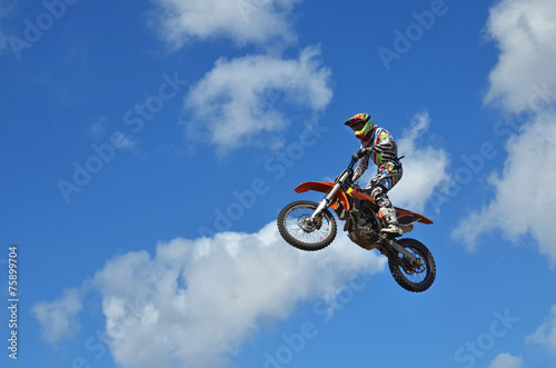 MX rider on the motorbike takes off from the hill