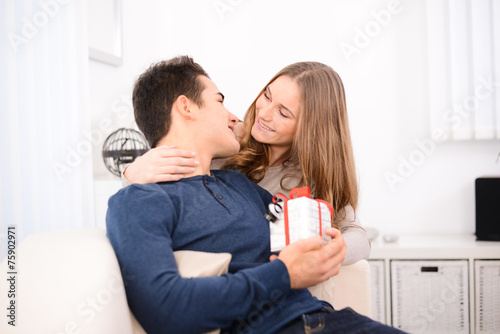 young couple man woman at home offering gifts for lover's day