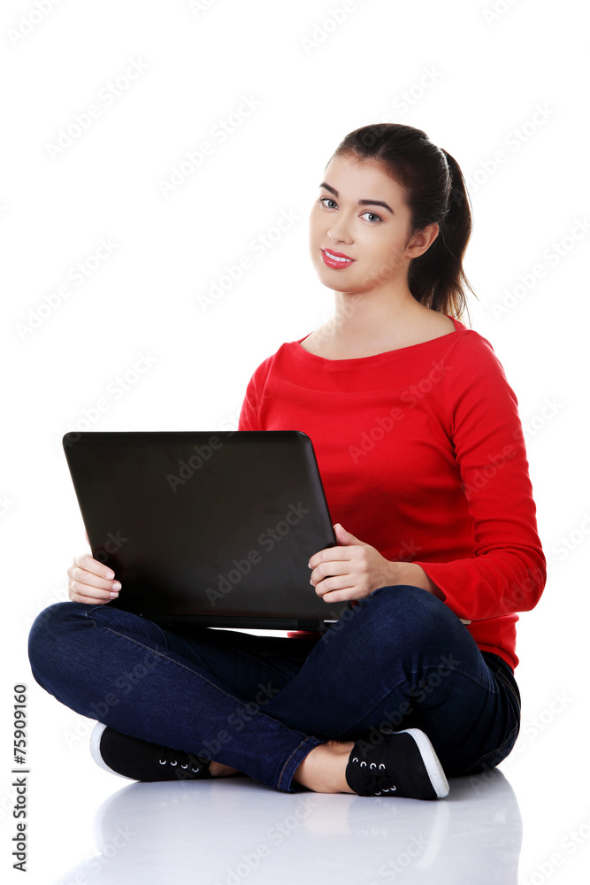 Naklejka premium Front view woman sitting cross-legged with laptop
