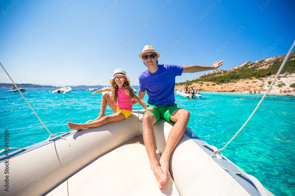 Young father with little girl resting on a big boat