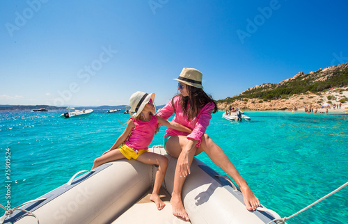 Cute girl and happy mom during vacation on boat in open sea © travnikovstudio