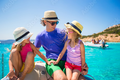 Young father with adorable girls resting on a big boat