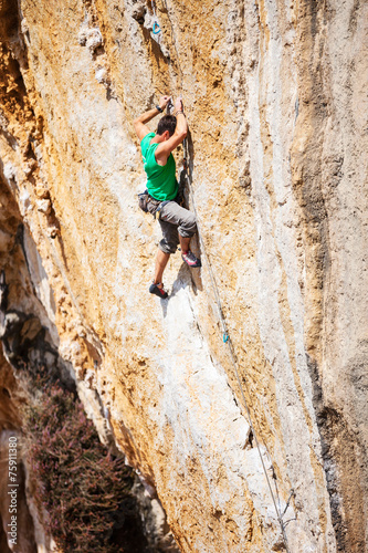 Young male rock climber on cliff