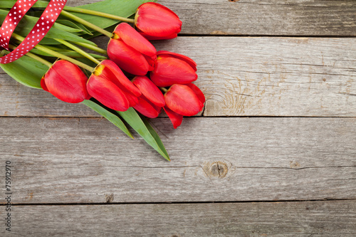 Fototapeta Naklejka Na Ścianę i Meble -  Fresh red tulips bouquet over wooden table background