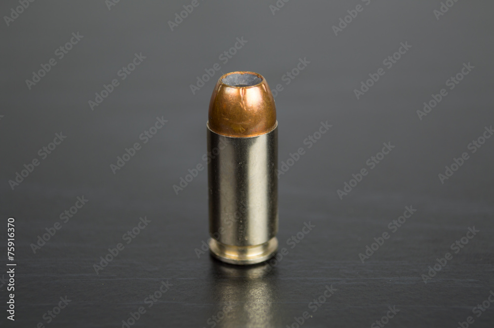 Single bullet for a gun on a black table Single bullet for a gun on a black table