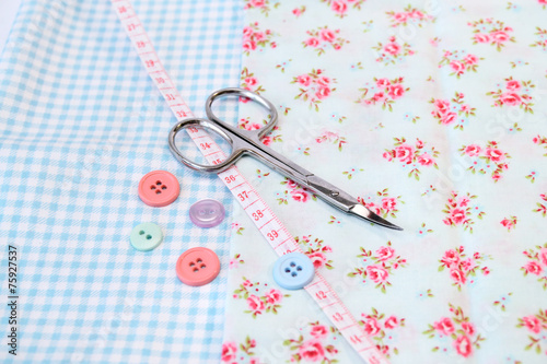 Sewing tools and vintage fabric background with scissors