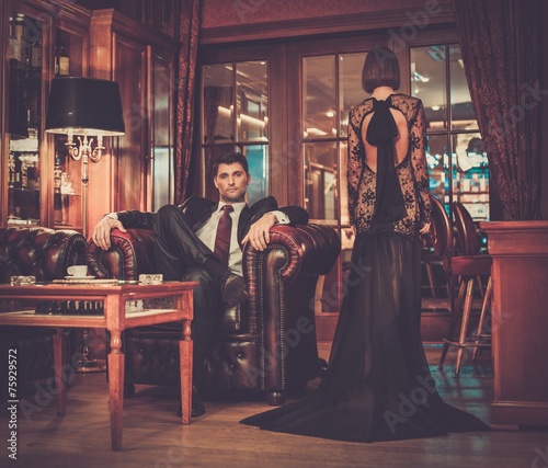 Elegant couple in formal dress in luxury cabinet interior