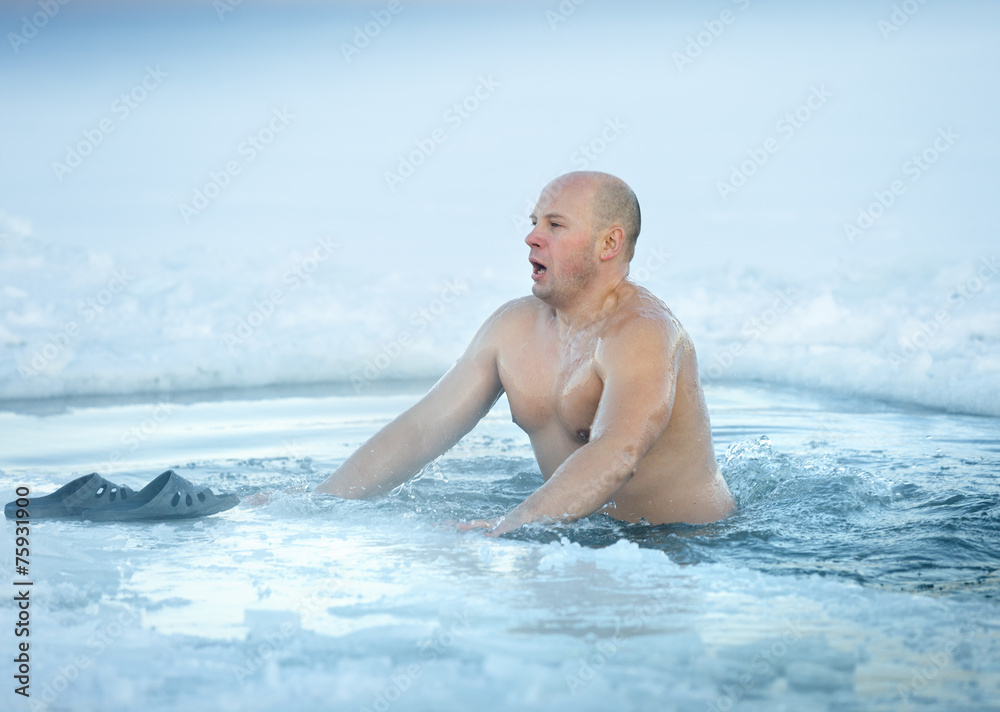 Winter swimming. Man in ice-hole
