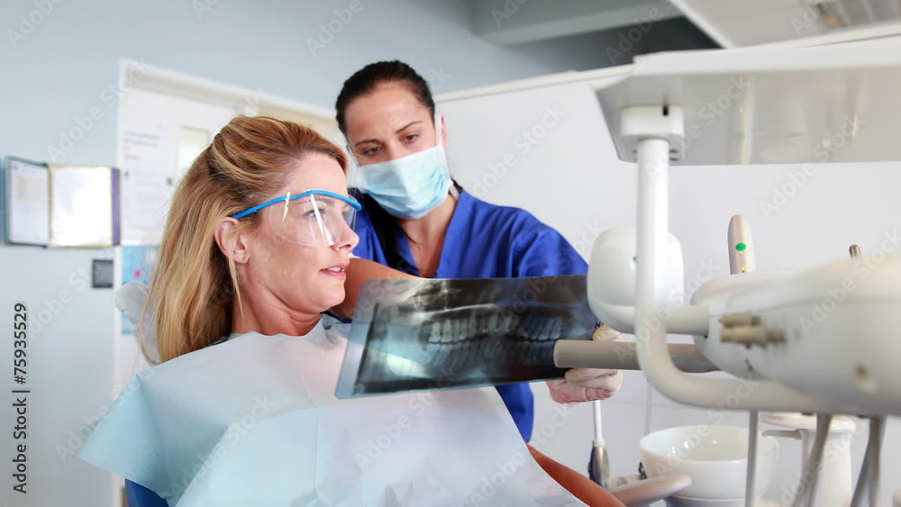 Dentist explaining x-ray report to her patient Dentist explaining x-ray report to her patient