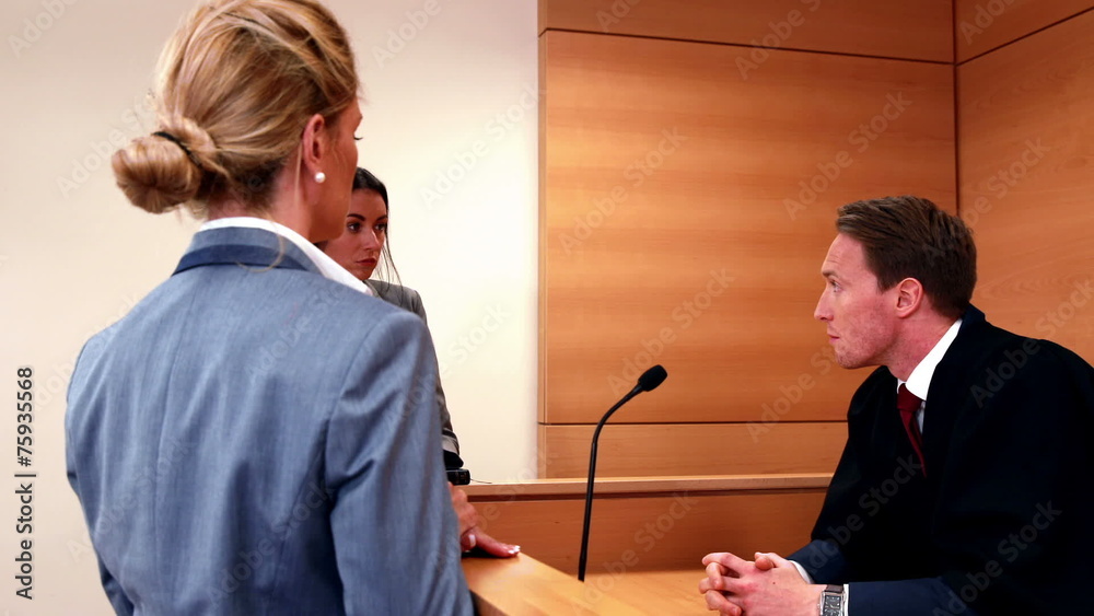 Serious judge speaking with two lawyers